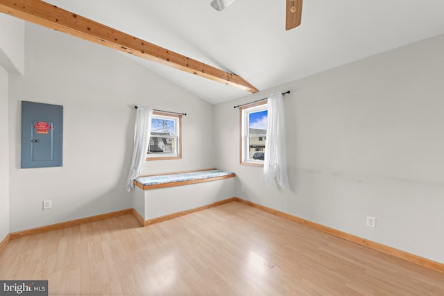 empty room featuring ceiling fan, electric panel, wood finished floors, lofted ceiling, and baseboards