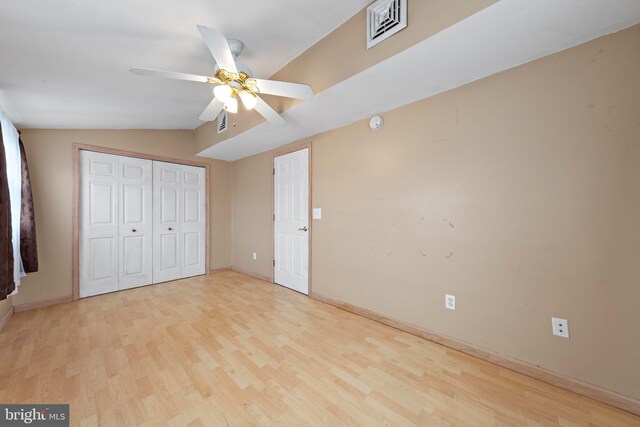 unfurnished bedroom with visible vents, baseboards, vaulted ceiling, and wood finished floors