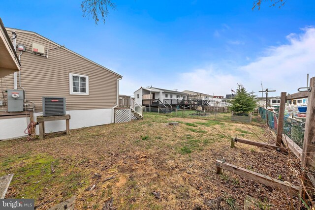 view of yard featuring a residential view, central AC, and a fenced backyard