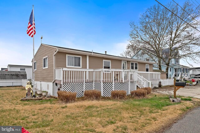 view of front facade featuring a wooden deck and a front lawn