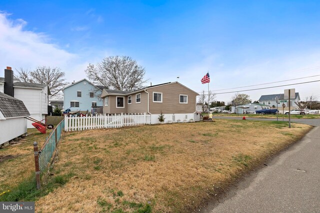 view of front of home with fence and a front lawn