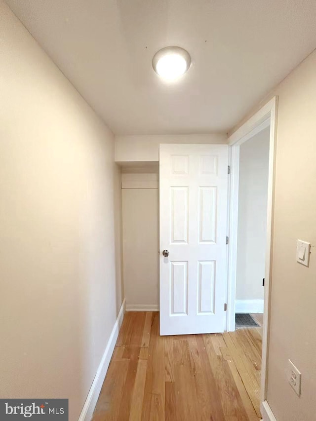 hall with light wood finished floors and baseboards