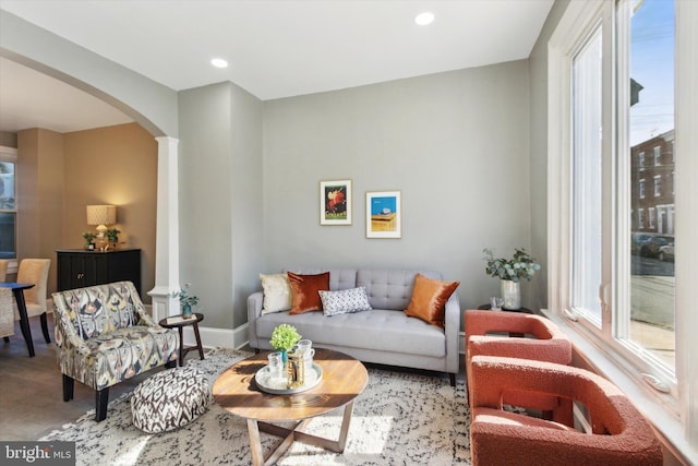 living room featuring recessed lighting, arched walkways, wood finished floors, and a healthy amount of sunlight