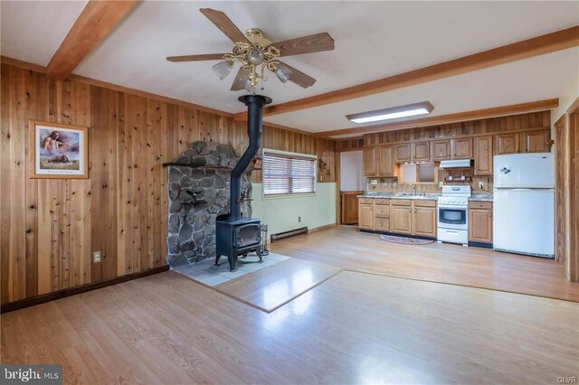 kitchen with light countertops, freestanding refrigerator, light wood-type flooring, beam ceiling, and stove