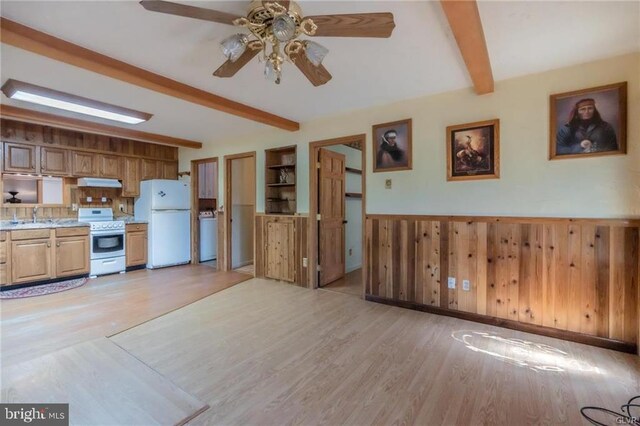 kitchen featuring white appliances, under cabinet range hood, light wood-style floors, beamed ceiling, and ceiling fan