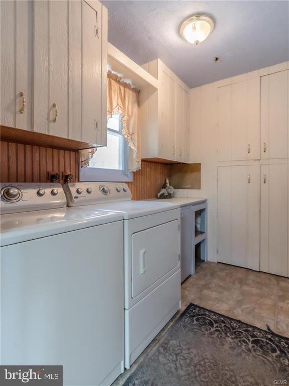 laundry room with cabinet space, separate washer and dryer, and light floors