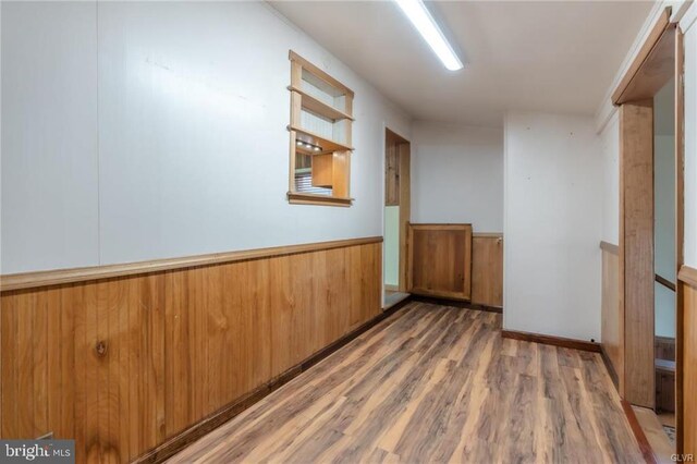 interior space featuring wood finished floors, wood walls, and wainscoting