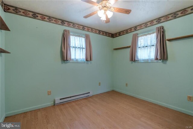 unfurnished room featuring a baseboard radiator, ceiling fan, light wood-style floors, and baseboards