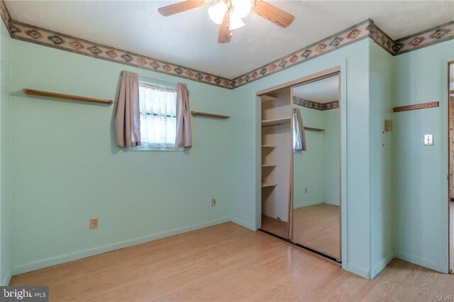 unfurnished bedroom featuring light wood finished floors, a closet, and baseboards