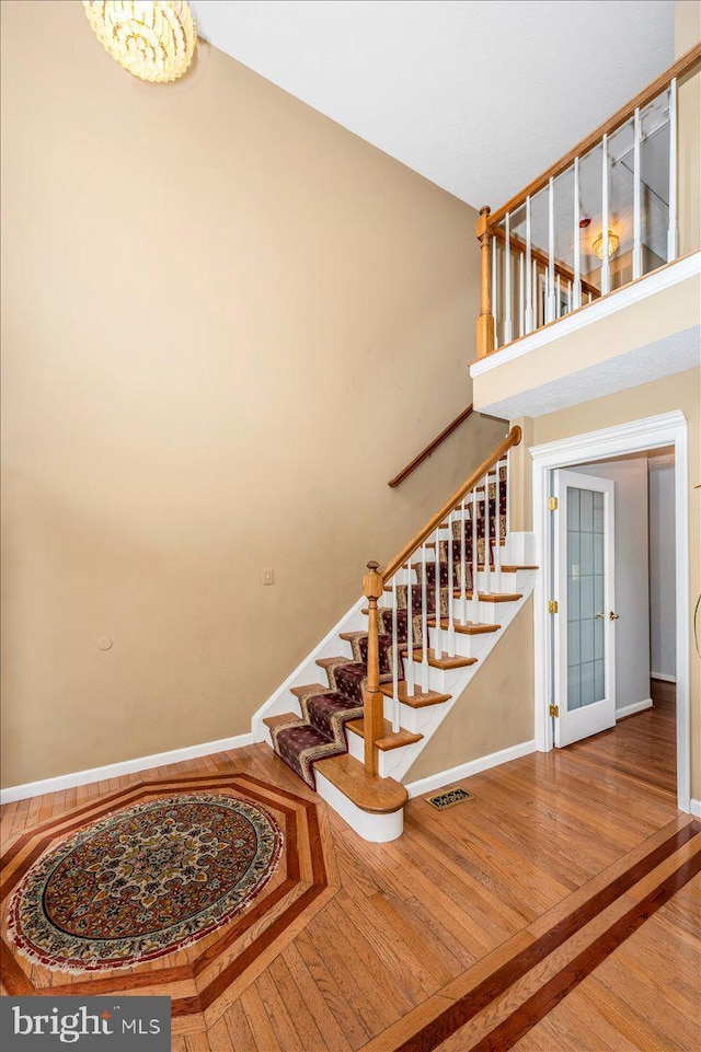 staircase featuring visible vents, baseboards, and wood finished floors