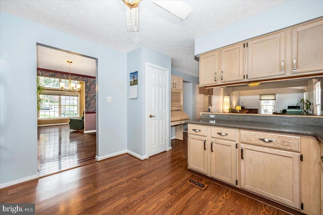 kitchen with baseboards, an inviting chandelier, light brown cabinets, dark countertops, and dark wood-style floors
