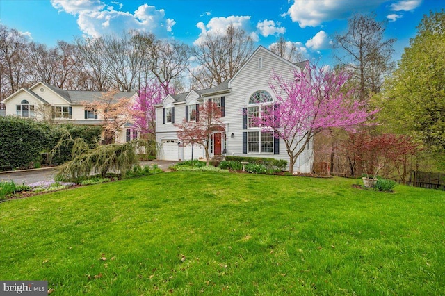 view of front of house featuring a garage, driveway, and a front lawn