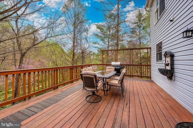 wooden terrace featuring outdoor dining area and area for grilling