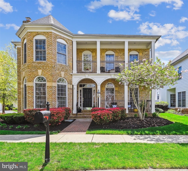 709 Pilot House Dr, Annapolis, MD 21401 - view of front of home with brick siding, a porch, a front lawn, and a balcony