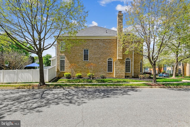 709 Pilot House Dr, Annapolis, MD 21401 - view of home's exterior featuring brick siding, fence, and a chimney