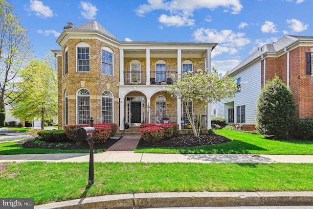 709 Pilot House Dr, Annapolis, MD 21401 - mediterranean / spanish-style house with a front lawn, brick siding, a balcony, and covered porch