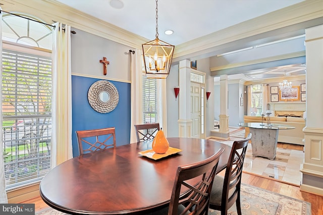 709 Pilot House Dr, Annapolis, MD 21401 - dining space featuring light wood-type flooring, decorative columns, an inviting chandelier, and crown molding