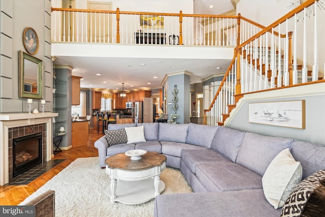 709 Pilot House Dr, Annapolis, MD 21401 - living room with recessed lighting, stairway, a towering ceiling, wood finished floors, and ornamental molding
