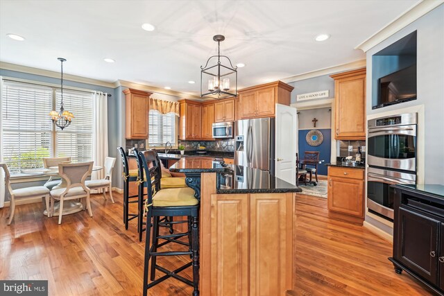 709 Pilot House Dr, Annapolis, MD 21401 - kitchen featuring stainless steel appliances, light wood-style flooring, tasteful backsplash, an inviting chandelier, and a breakfast bar area
