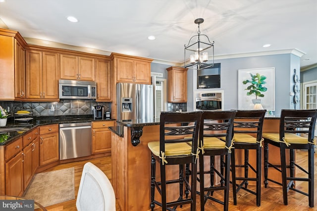 709 Pilot House Dr, Annapolis, MD 21401 - kitchen with recessed lighting, stainless steel appliances, a kitchen island, crown molding, and light wood-style flooring