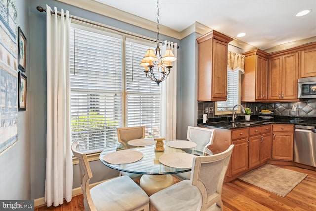 709 Pilot House Dr, Annapolis, MD 21401 - kitchen with a sink, an inviting chandelier, light wood finished floors, backsplash, and appliances with stainless steel finishes