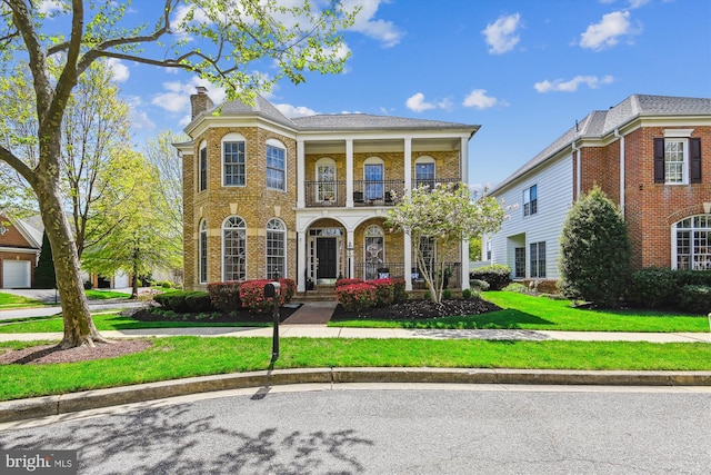 709 Pilot House Dr, Annapolis, MD 21401 - view of front of house featuring a front lawn, a chimney, a balcony, and brick siding