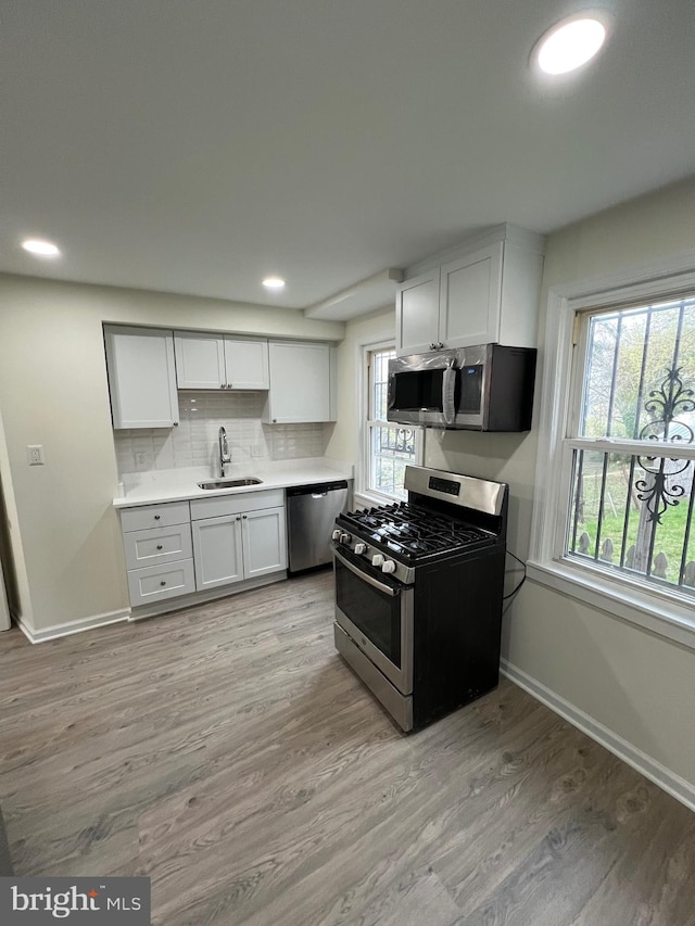 808 Division Ave NE, Washington, DC 20019 - kitchen with stainless steel appliances, light wood-style flooring, a sink, and backsplash