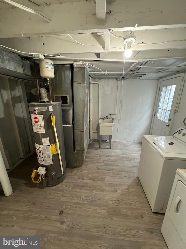 808 Division Ave NE, Washington, DC 20019 - basement with visible vents, water heater, wood finished floors, a sink, and washing machine and dryer