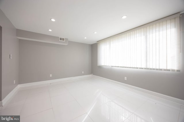 unfurnished room featuring recessed lighting, light tile patterned floors, and baseboards