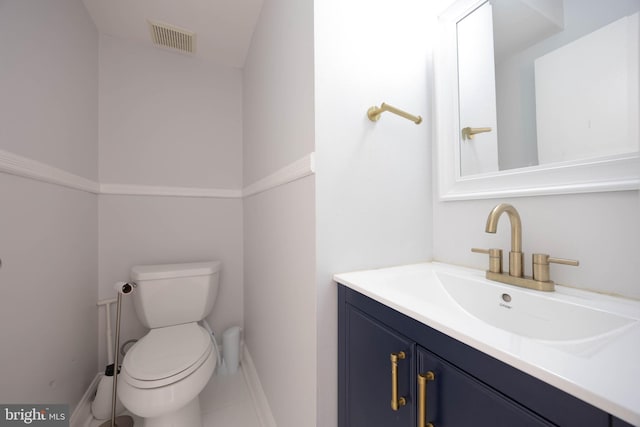 half bathroom featuring baseboards, vanity, and toilet