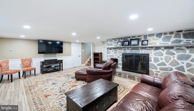 living area featuring a fireplace, wood finished floors, stairs, and recessed lighting