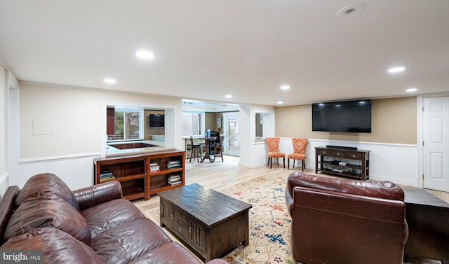 living room featuring crown molding, a wainscoted wall, light wood-style floors, and recessed lighting