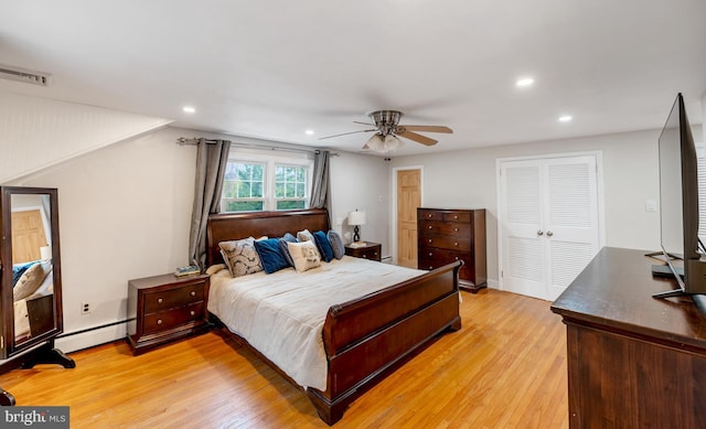 bedroom with light wood-style flooring, visible vents, recessed lighting, a closet, and a baseboard radiator