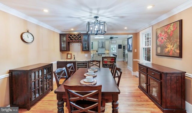 dining space featuring recessed lighting, light wood finished floors, wine cooler, crown molding, and baseboards