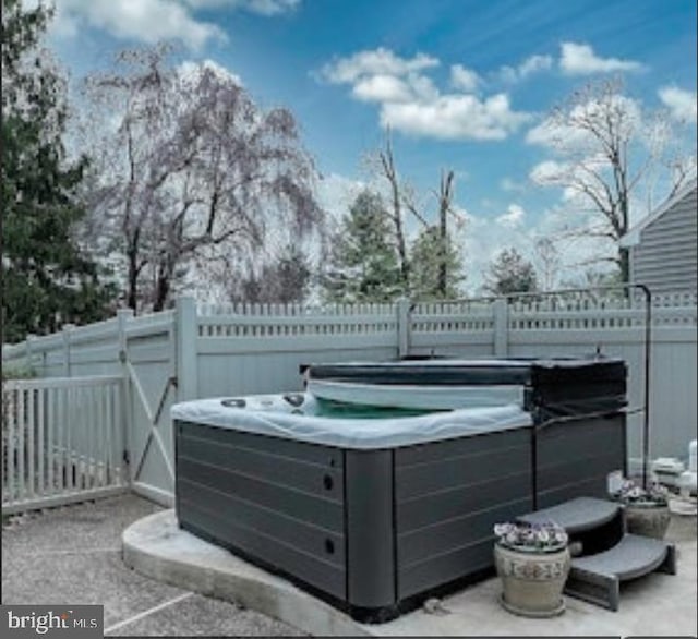 view of patio with a fenced backyard and a hot tub