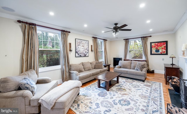 living area featuring baseboards, recessed lighting, ceiling fan, and crown molding