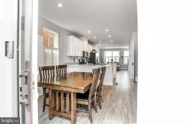 dining space with light wood-style floors, baseboards, and recessed lighting