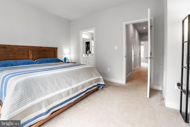 bedroom featuring light carpet, baseboards, and connected bathroom