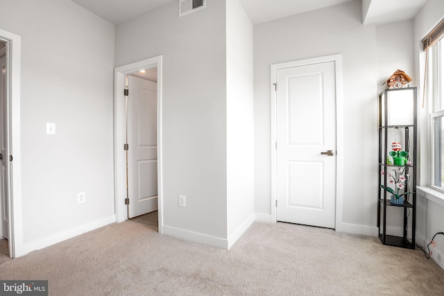 unfurnished bedroom featuring baseboards, visible vents, and carpet floors
