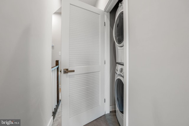 clothes washing area with stacked washing maching and dryer and laundry area