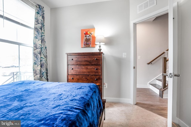 carpeted bedroom featuring baseboards and visible vents