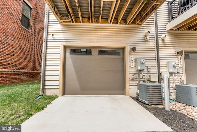 garage featuring concrete driveway and central AC
