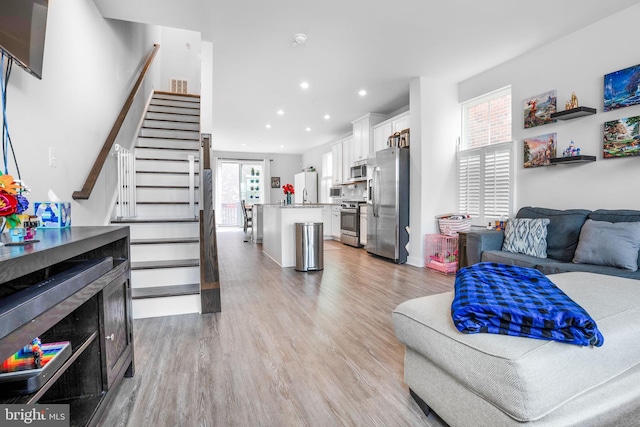 living area featuring recessed lighting, stairway, light wood-style flooring, and visible vents