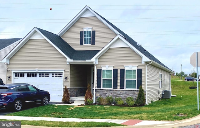 view of front of home featuring roof with shingles, stone siding, an attached garage, a front lawn, and central AC unit