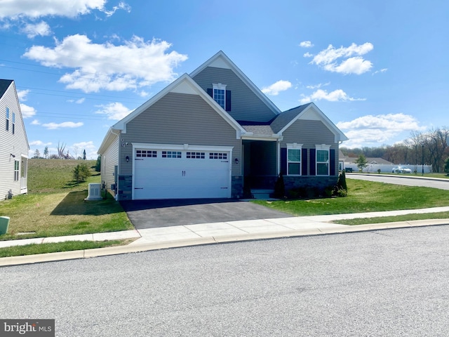 view of front of home featuring a garage, central air condition unit, driveway, and a front lawn