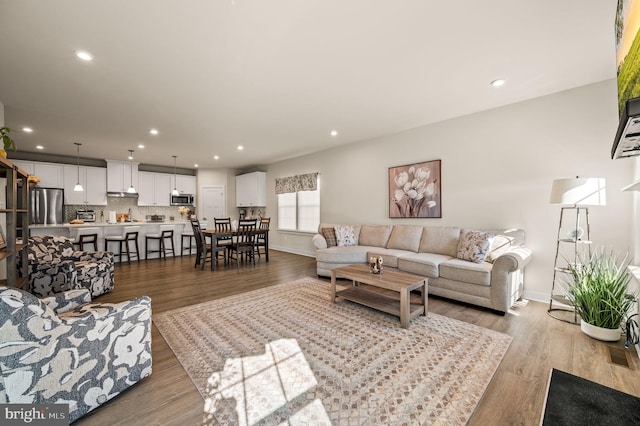 living area featuring recessed lighting, baseboards, and wood finished floors