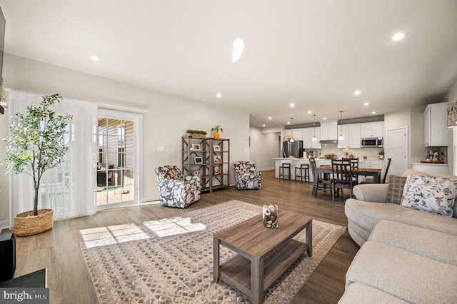 living area featuring wood finished floors, baseboards, and recessed lighting
