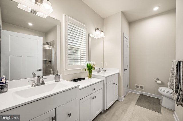 bathroom featuring a shower stall, a sink, visible vents, and toilet