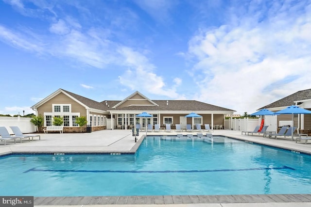 community pool with fence and a patio