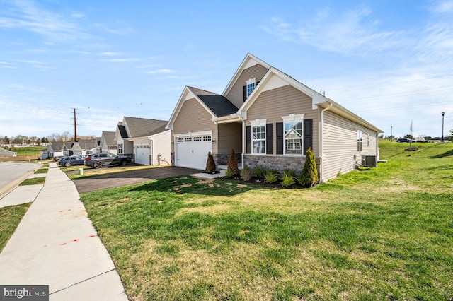 view of front of home with driveway, a garage, stone siding, and a front lawn